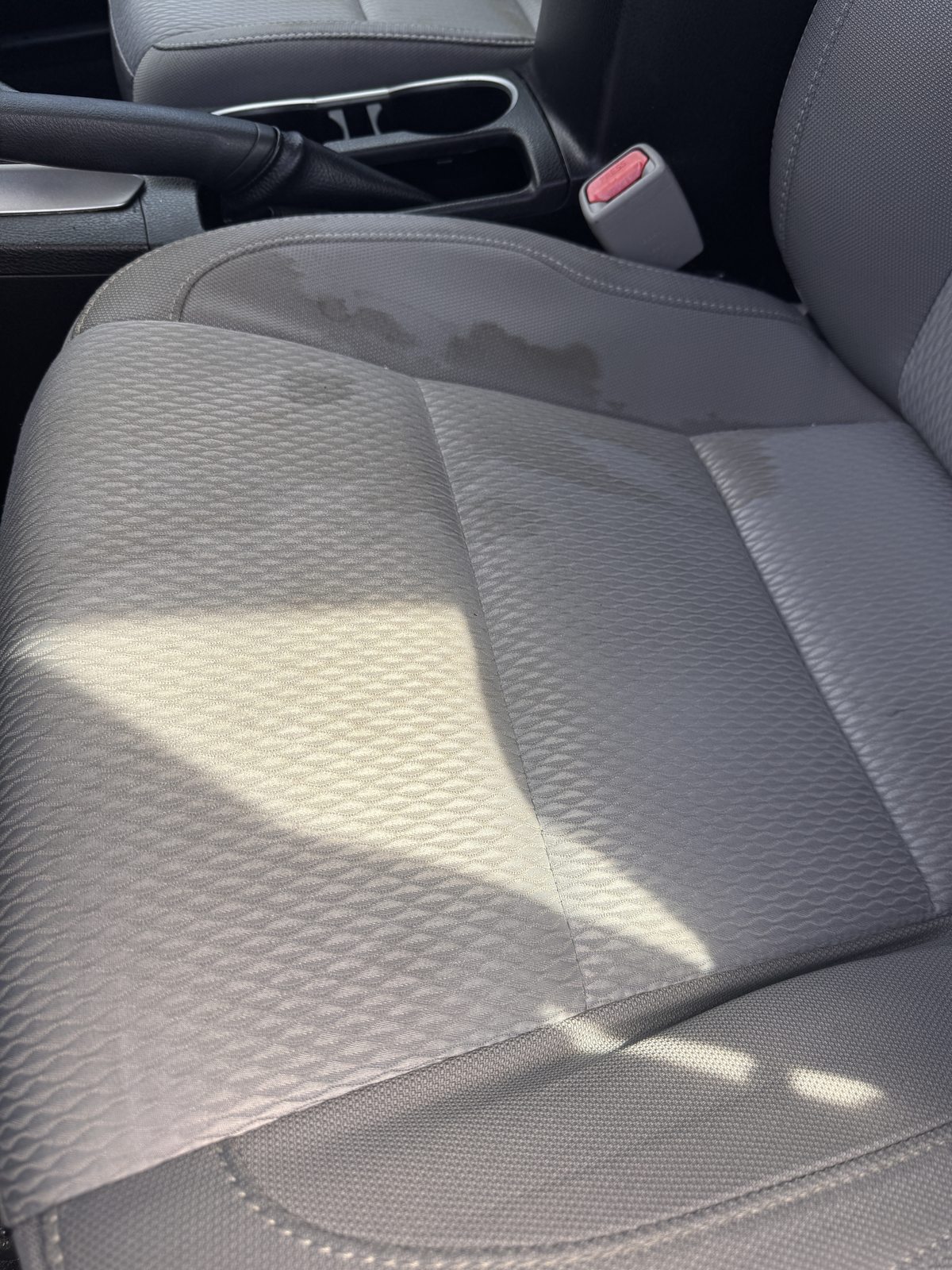 Stained gray cloth car seat before cleaning